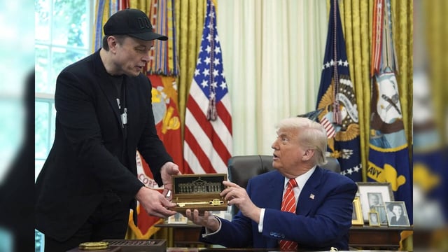 President Donald Trump, right, presents a key to Elon Musk during a news confere...