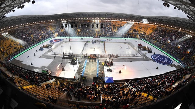 Stadionübersicht mit illuminierten Rängen.