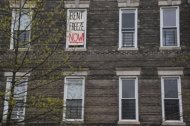 A 'Rent Freeze Now' sign hangs in a window in Brooklyn.
