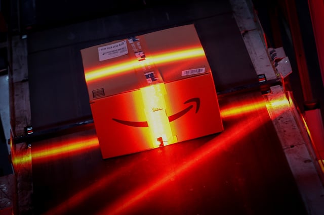 A fast-moving conveyor moves a package through a scanning machine on its way to a delivery truck during operations on Cyber Monday at Amazon's fulfillment center in Robbinsville, New Jersey, U.S., November 29, 2021. REUTERS/Mike Segar/File Photo