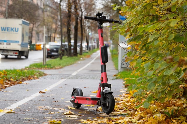 E-Scooter der Marke Voi zum Mieten auf dem Gehweg, bzw. Bürgersteig in Augsburg abgestellt im Herbst. Symbol für rutschiges fahren und Belastung durch falsch geparkte Scooter.