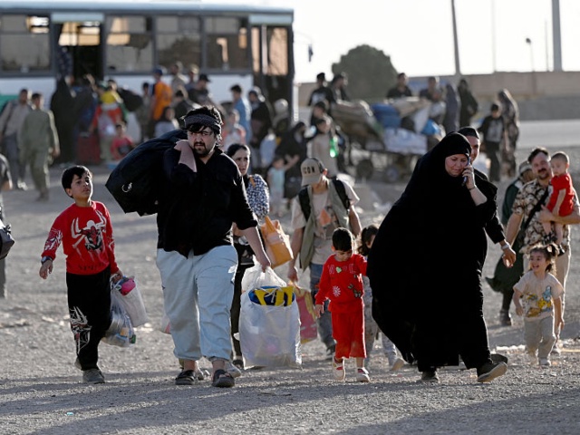 Afghan refugees carrying their belongings arrive at the zero point of the Islam Qala border crossing between Afghanistan and Iran on June 28, 2025, following their deportation from Iran. (Photo by Wakil Kohsar / AFP) (Photo by WAKIL KOHSAR/AFP via Getty Images)
