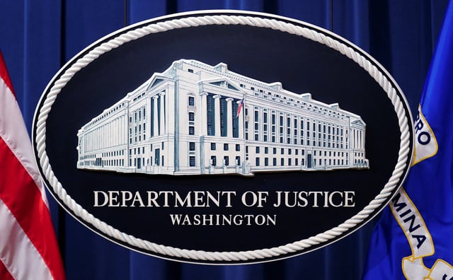 A U.S. Justice Department logo or seal showing Justice Department headquarters, known as "Main Justice," is seen behind the podium in the Department's headquarters briefing room before a news conference with the Attorney General in Washington, January 24, 2023.  REUTERS/Kevin Lamarque/File Photo