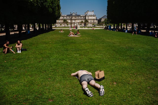 Des personnes bronzent dans le jardin du Luxembourg à Paris alors que la France traverse un important épisode de canicule, le 30 juin 2025.