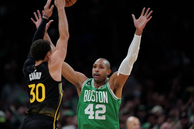 Golden State Warriors guard Stephen Curry throws the ball as Boston Celtics center Al Horford defends in the second half of an NBA basketball game, Thursday, Jan. 19, 2023, in Boston.