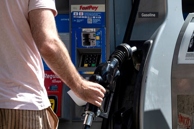 A customer holds a fuel nozzle at a Chevron gas station in San Francisco, California, US, on Friday, June 7, 2024. Photographer: David Paul Morris/Bloomberg via Getty Images