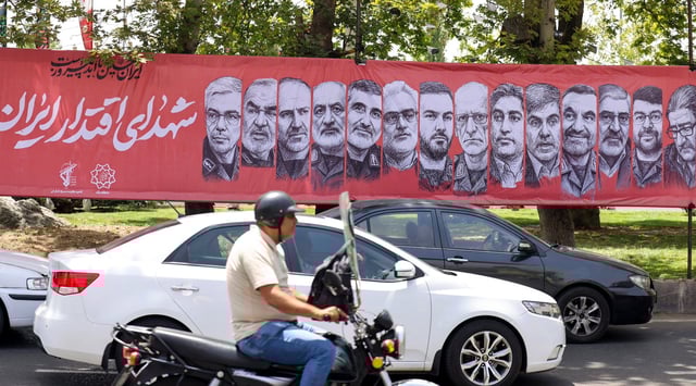 Traffic moves past a large banner depicting Iranian commanders and scientists killed in Israeli strikes during the 12-day war between Iran and Israel, at Tajrish Square in the capital Tehran, June 30, 2025 (Atta Kenner /AFP via Getty Images)
