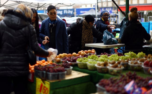 People shop to buy fruit and vegetables at a stall in Lewisham Market, south east London, Britain, March 9, 2023. REUTERS/Hannah McKay/ File Photo
