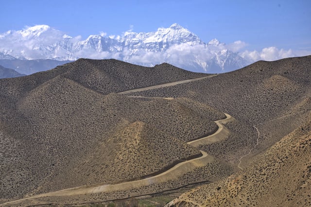 A dirt road through a barren mountains leads to the abandoned Samjung village in the Mustang region, 462 kilometers (288 miles) west of Kathmandu, Nepal, Thursday, April 17, 2025. (AP Photo/Niranjan Shrestha)