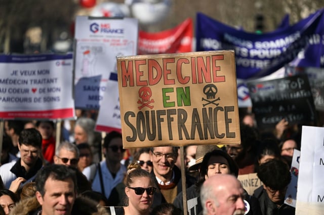 Un manifestant brandit une pancarte "Médecine en souffrance" lors d'une mobilisation du secteur privé, le 14 février 2023 à Paris