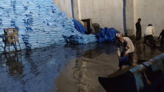 Workers at the inundated godown on Monday. (HT Photo)