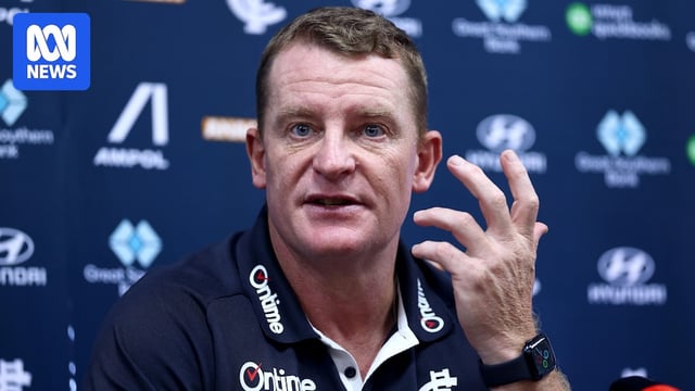 Michael Voss motions with left hand while speaking