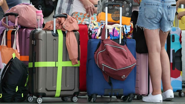 Flugreisende warten mit ihrem Gepäck am Check-In im Flughafen Leipzig-Halle.