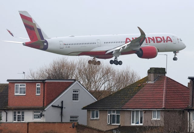 An Air India passenger plane flies near houses as it makes its landing approach to Heathrow Airport in west London, Britain, January 28, 2025.  REUTERS/Toby Melville/File Photo