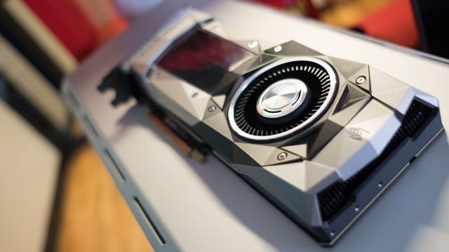 A stylized photo of an Nvidia GeForce GTX 1080 Ti graphics card, resting on top of a desktop PC.