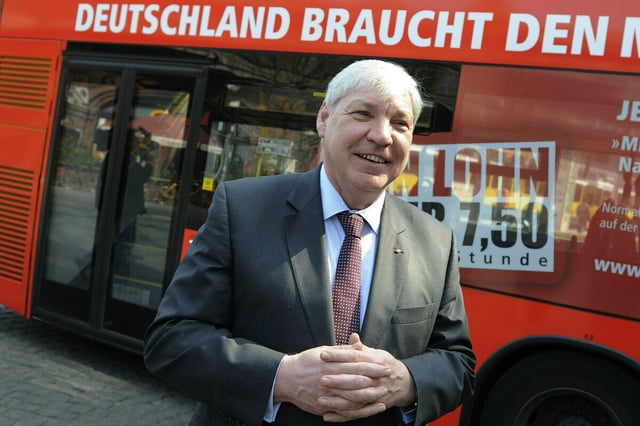 Vor einem Bus der Berliner Verkehrsbetriebe mit der Aufschrift "Deutschland braucht den Mindestlohn" steht der DGB-Vorsitzende Michael Sommer