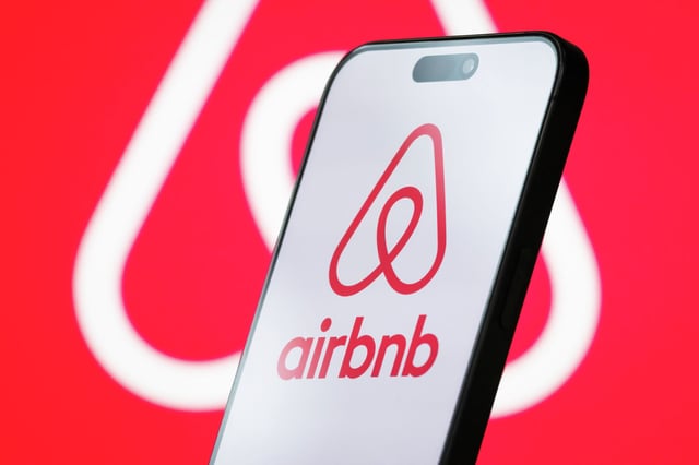 FILE: In this photo illustration, the logo of Airbnb Inc. is displayed on a smartphone screen, with the company’s branding visible in the background, on April 26, 2025.