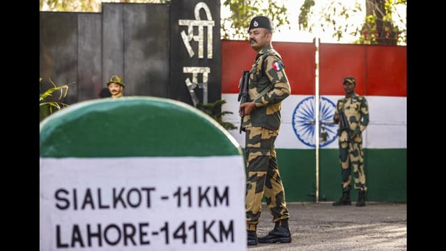 Border Security Force personnel stand guard near the last gate of the India-Pakistan International border at Suchetgarh octroi post on the outskirts of Jammu. (PTI)