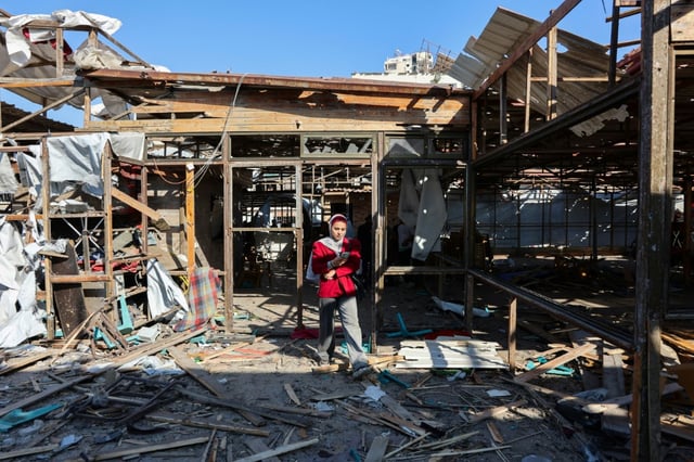 Une Palestinienne marche au milieu des dégâts au café Al-Baqa, dévasté par une frappe israélienne sur le front de mer, à Gaza-ville le 30 juin 2025