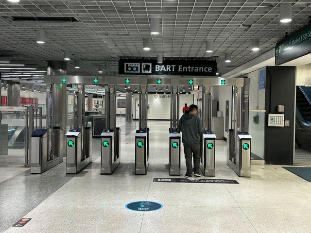 A BART commuter passes through the fare gate that was left open because of a Clipper outage on July 1, 2025.