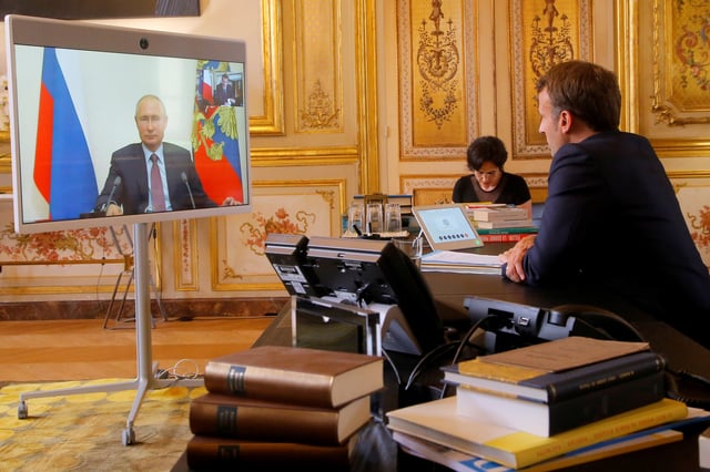 French President Emmanuel Macron talks with Russian President Vladimir Putin during a video conference at the Elysee Palace in Paris, France, June 26, 2020. Michel Euler/Pool via REUTERS/File Photo