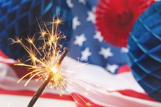 US flags with Happy 4th of July paper fans decorations  for American Independence Day. Stars and stripes USA flag background with fireworks
