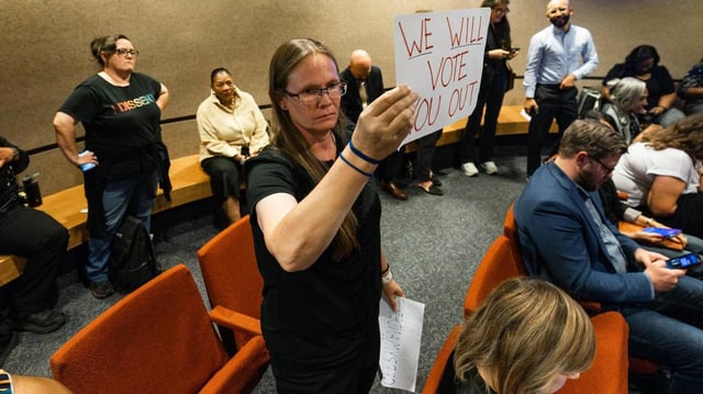 Fort Worth resident Crystal Betts holds a sign saying “We Will Vote You Out” after the Tarrant County Commissioners voted 3-2 to approve county-wide redistricting during a Tarrant County Commissioners Court meeting at the Tarrant County Administration Building in Fort Worth on Tuesday, June 3, 2025.