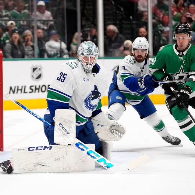 FILE - Vancouver Canucks goaltender Thatcher Demko (35) watches a shot go wide of the net as Conor Garland (8) helps against pressure from Dallas Stars right wing Evgenii Dadonov (63) in the first period of an NHL hockey game in Dallas, April 8, 2025. (AP Photo/LM Otero, File)