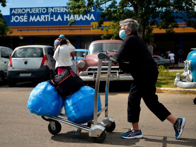 A Cuban-American carries luggage as she leaves Havana's Jose Marti International Airport on November 20, 2020. - Used to avoiding difficulties and now that international flights have resumed, Cubans reactivated their archaic but efficient system of "mules" (human couriers), especially in the Havana-Miami flights, to mitigate the cut-off of family remittances and other restrictions imposed by the government of US President Donald Trump. Western Union is closing its Cuba operation on November 23, following new US sanctions. (Photo by Yamil LAGE / AFP) (Photo by YAMIL LAGE/AFP via Getty Images)