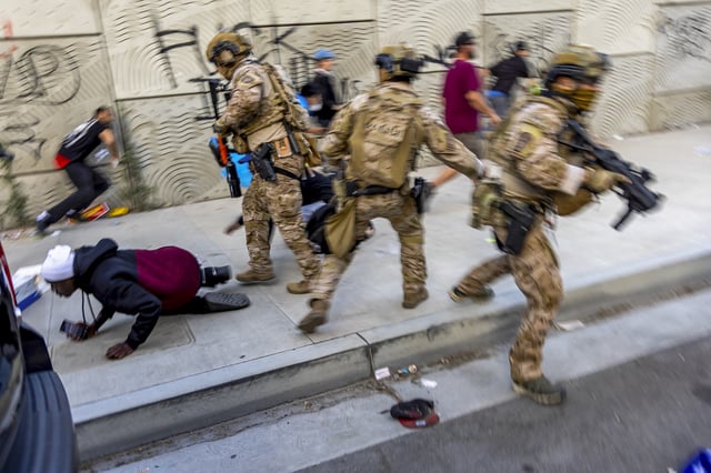 National Guard officers can be seen in front of the Metro Detention Center in Downtown Los Angeles on June 12, 2025. (Photo by Benjamin Hanson / Middle East Images via AFP) (Photo by BENJAMIN HANSON/Middle East Images/AFP via Getty Images)