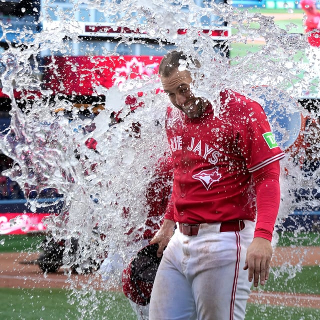 Toronto Blue Jays' Vladimir Guerrero Jr. douses teammate George Springer with water after their victory over the New York Yankees in MLB baseball action in Toronto on Tuesday, July 1, 2025. THE CANADIAN PRESS/Frank Gunn