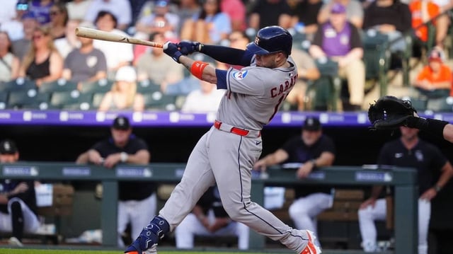 Jul 1, 2025; Denver, Colorado, USA; Houston Astros catcher Victor Caratini (17) singles in the second inning against the Colorado Rockies at Coors Field. Mandatory Credit: Ron Chenoy-Imagn Images