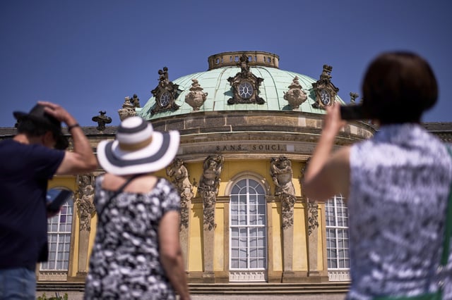 Visitors takes photos of Sanssouci Palace, the summer home of King Frederick II of Prussia, in Potsdam, Germany, June 17, 2025. (AP Photo/Markus Schreiber)