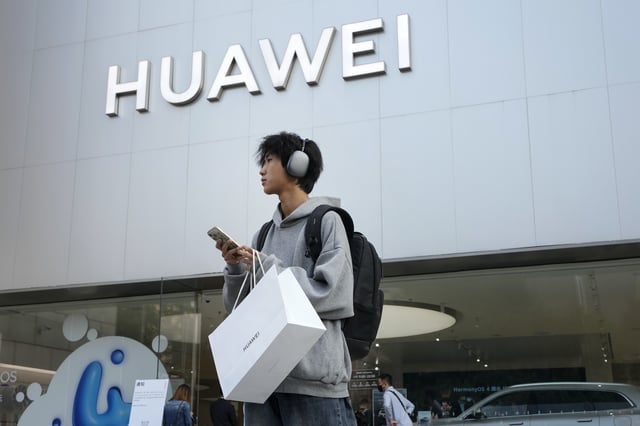 FILE - A customer carries his purchased Huawei product outside a Huawei store after he attended the Huawei new product launch conference in Beijing, on Sept. 25, 2023. (AP Photo/Andy Wong, File)