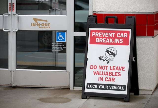 A sign warns patrons of car break-ins at the In-N-Out Burger off Hegenberger Road in Oakland, Calif., on Monday, Jan. 22, 2024. The company is closing its only Oakland restaurant, citing ongoing issues with crime. (Jane Tyska/Bay Area News Group)