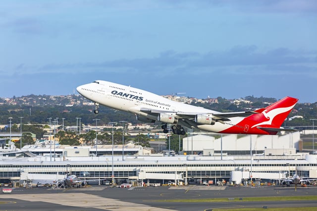 Sydney, Australia - November 26, 2017: Qantas Longreach 747 VH-OJT "Fraser Island" taking off from Sydney Airport, with domestic terminal in background.