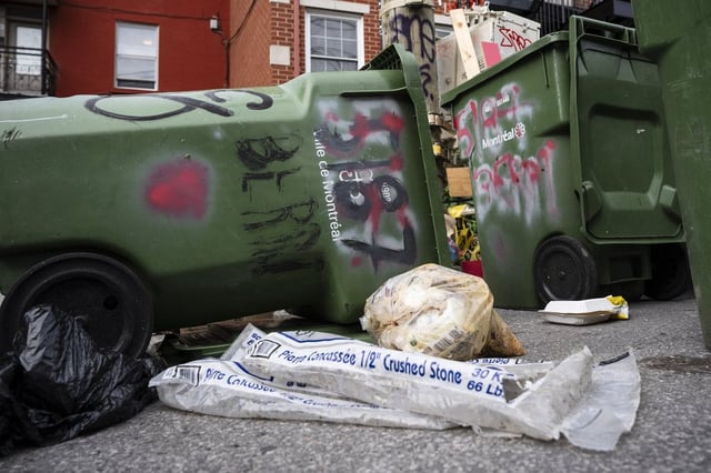 Garbage, which was put out for pickup on the incorrect day, lays on the ground next to recycling bins that were collected by sanitation workers in Montreal on Wednesday, June 18, 2025. THE CANADIAN PRESS/Christopher Katsarov