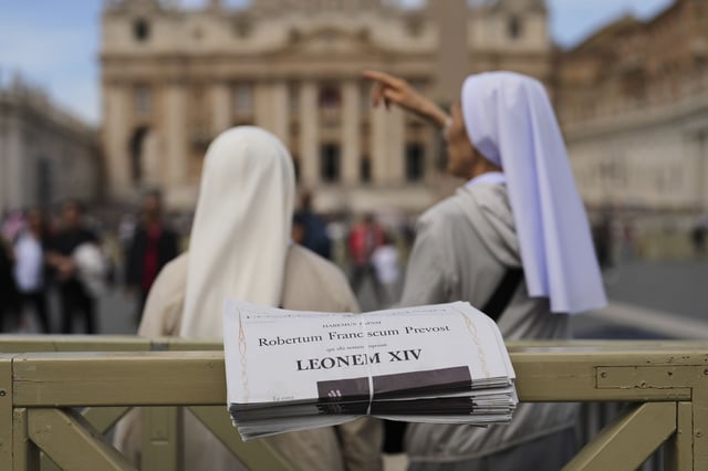 FILE - Nuns stand next to copies of L'Osservatore Romano newspaper with headlines in Latin of Pope Leo XIV at the Vatican, Friday, May 9, 2025, a day after he was elected as the first North American pope. (AP Photo/Francisco Seco, file)