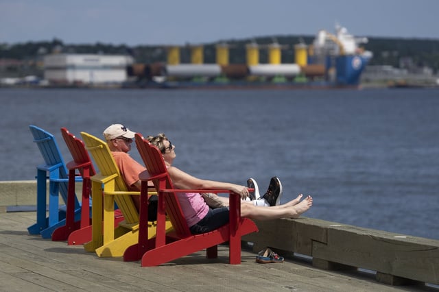 People rest on chairs on the Halifax Waterfront in Halifax on Thursday, July 6, 2023. THE CANADIAN PRESS/Darren Calabrese