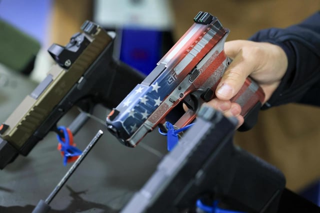 A visitor looks at a handgun in the GForce Arms booth during the 2025 NRA Annual Meetings&amp; Exhibits held in the Georgia World Congress Center on April 26, 2025, in Atlanta. (Joe Raedle/Getty Images North America/TNS)
