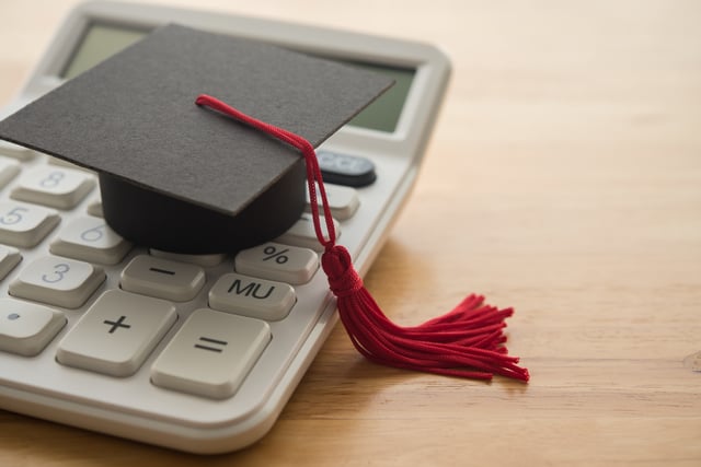 Stock image/file photo: A mortarboard laid on top of a calculator.
