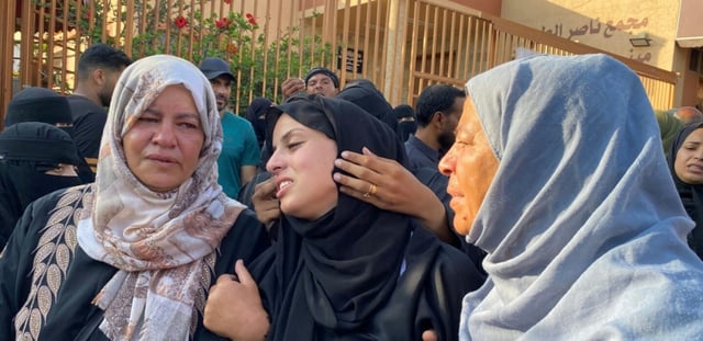 Des femmes palestiniennes de la bande de Gaza pleurent des proches lors de leurs funérailles après qu'ils ont été tués par une frappe israélienne sur un camp de personnes déplacées, à l'hôpital Nasser de Khan Younès le 2 juillet 2025