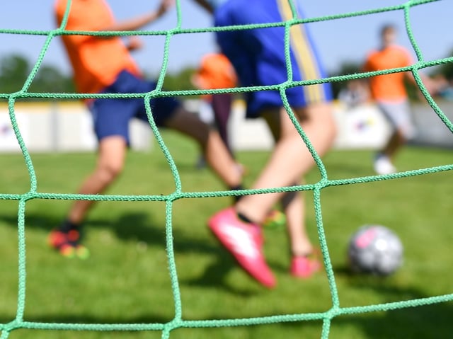 Kinder spielen auf einem Trainingsplatz Fußball (Symbolbild).