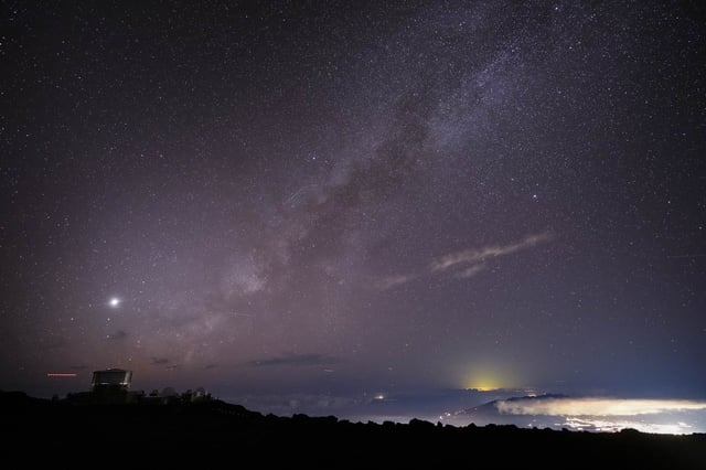 FILE - The Milky Way is seen over the Haleakala Observatory and the lights of Kahului, at right, Saturday, Nov. 23, 2024 at the summit of Haleakala National Park near Kula, Hawaii. (AP Photo/Lindsey Wasson, File)
