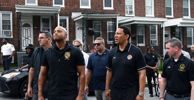Gov. Wes Moore and Ivan Bates, State’s Attorney for Baltimore City, survey houses in the Four by Four neighborhood during a Community Walk with Baltimore Mayor Brandon Scott, officials and community members. On right is Eric Costello, District 11 council member.