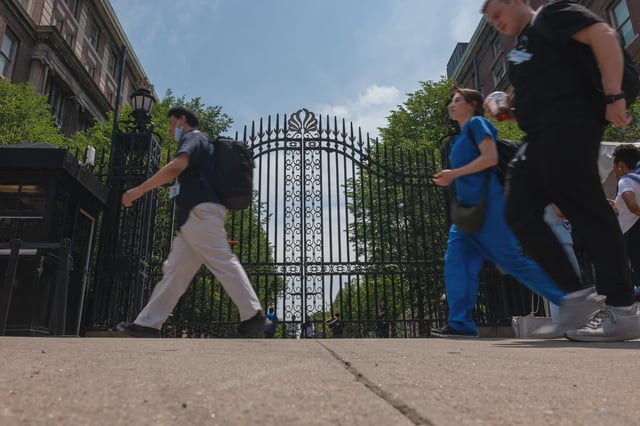 Pedestrians walk by Columbia University in Upper Manhattan.