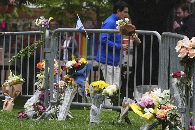 FILE - Bouquets of flowers stand along a makeshift memorial for victims of an attack outside of the Boulder County, Colo., courthouse on Tuesday, June 3, 2025, in Boulder, Colo. (AP Photo/David Zalubowski,File)
