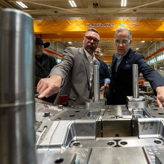 Prime Minister Mark Carney and facility GM Rob Gignac look at an automotive light mould at ABC Windsor in Windsor, Ont., Wednesday, March 26, 2025. THE CANADIAN PRESS/Frank Gunn