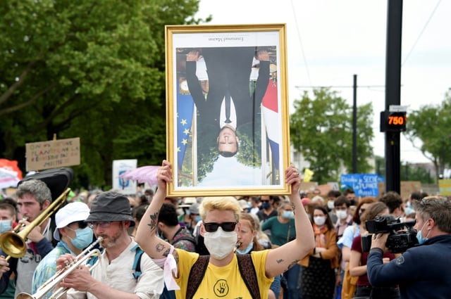 Un manifestant tient un portrait d'Emmanuel Macron lors d'une "Marche pour le climat", le 9 mai 2021 à Nantes