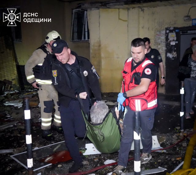 A police officer and a medical worker evacuate a resident from an apartment building damaged during a Russian drone strike, amid Russia's attack on Ukraine, in Odesa, Ukraine July 3, 2025. Press service of the State Emergency Service of Ukraine in Odesa region/Handout via REUTERS